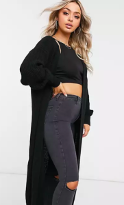 une fille blonde de face portant un gilet long noir