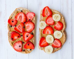 beurre d’érable préparé sur des tartines de pain avec des fraises et des morceaux de bananes