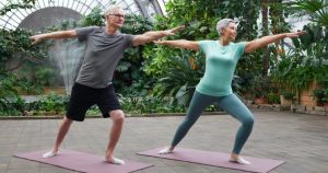 un homme et une femme seniors sur des tapis dans une posture de yoga