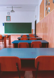 salle de classe vide avec des tables et un tableau