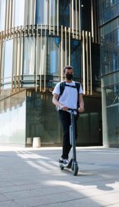 un homme dans une ville entrain de rouler en trottinette électrique