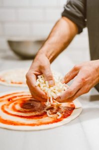 Préparation d'une pizza Margherita, une pate, de la sauce tomate et du fromage