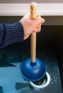 utilisation d'une ventouse pour déboucher un évier
