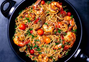 un wok électrique avec un plat de nouilles et des legumes