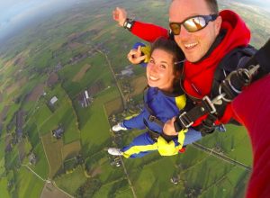 Le parachutisme en tandem un homme et une femme entrain de faire du parachutisme