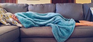 un homme dans un sofa entrain de tester des techniques de grand mère anti ronflement