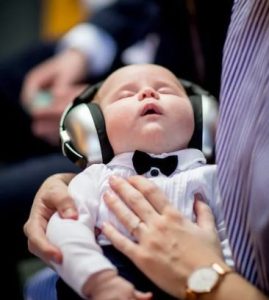 un bebe avec un casque insonorisant pour pouvoir réussir a dormir au milieu du bruit 