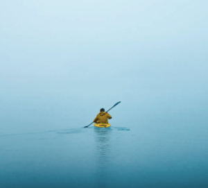 un homme sur un kayak gonflable seul sur une rivière