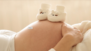 un ventre de femme en enceinte avec des petits chaussons