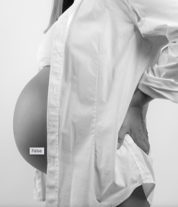 le ventre d'une femme enceinte avec une chemise blanche