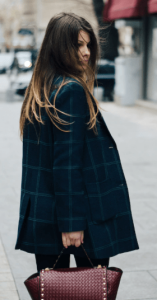 une femme dans la rue avec un trench coat de couleur sombre, 