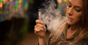 Une femme avec une cigarette électronique fumant un e-liquide Francais