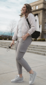 Une jeune fille dans la rue avec une coupe vent pour femme blanc et un sac en bandouillaire