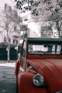 une 2CV rouge dans la rue avec une assurance auto au tiers
